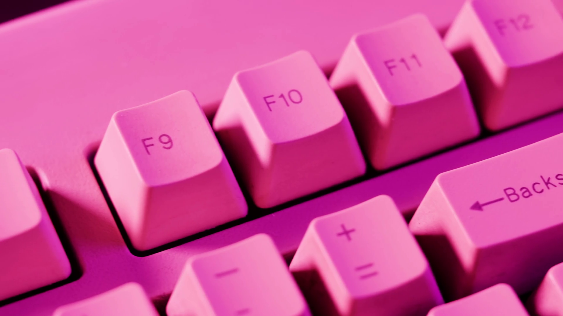 Old retro keyboard closeup. Computer buttons in neon pink light top