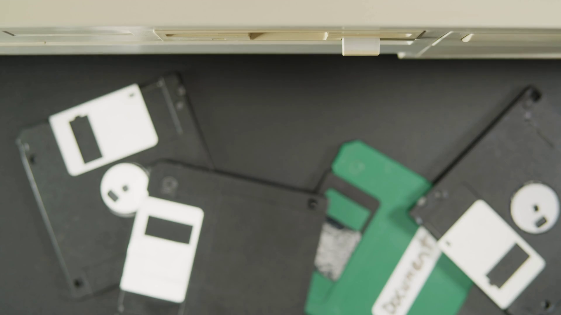 Using diskette closeup. Old floppy disk, disc drive top view. Retro