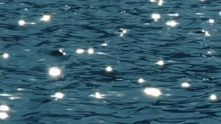 Slow motion of golden glittering sea surface, abstract background.