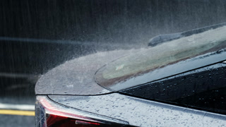 Blue car with red lights in the rain.