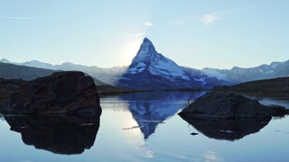 Matterhorn Mountain and Reflection in Lake Stellisee at Sunset. Sun is Setting behind the Mountain. Swiss Alps. Valais, Switzerland
