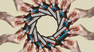 hands holding cassette tapes made into a circular pattern