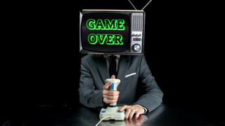 cool Mr Television head playing computer games using joystick with game over appearing on the screen