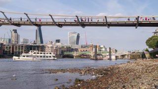 people crossing the millennium bridge over the river thames in london