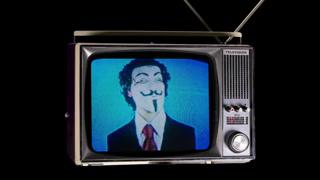 a cutout retro television turning in space with man with vendetta mask on the screen