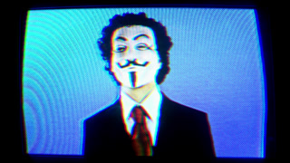 cutout retro television turning in space with man with vendetta mask on the screen