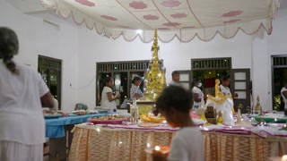 2023-05-05 - Mirissa, Sri Lanka. Bandaramulla temple. Devotees hold candles, offerings at Vesak inside Sri Lankan temple. Buddhists lamps