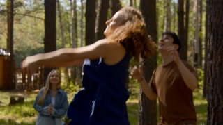 People have fun playing volleyball in park. Stock footage. Friends are actively playing volleyball in forest clearing. Fun ball games for