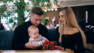Beautiful Young Caucasian Couple Sitting at Table on Terrace of Cafe and Looking Screen Smartphone Serious People Discussing Using Gadget Outdoors Summertime