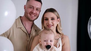 Beautiful Caucasian Parents with their Adorable Little Baby Happy Couple Kissing and Kiss Beloved Child