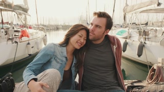 Loving couple kissing while sitting on the embankment