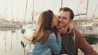 Loving couple kissing while sitting in the harbor
