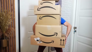 ROME, ITALY - MARCH 15, 2024: Amazon courier in blue T-shirt holding amazon prime packages and dancing near the customer door, express