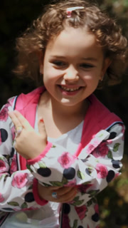 Child dancing. little cute curly girl dancing, having fun at children's birthday outdoor party. kids concept.