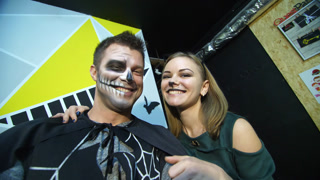 Frightening portrait of a man in black and a girl in a cat costume screaming. Spooky makeup for Halloween celebration.