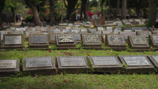 Bandung, Indonesia - March 27, 2026: Rows of graves in a Muslim cemetery with visitors present, showing burial traditions, remembrance, and religious culture in Indonesia. Calm and reflective atmosphere in a public graveyard.