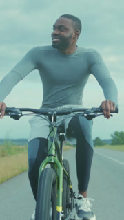 Man pedals through countryside peacefully, Cyclist wearing sports gear travels along peaceful countryside highway
