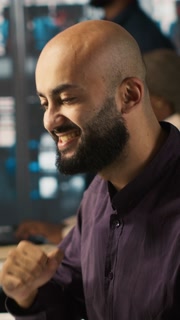 Vertical video Happy man in office reviewing financial graphs, pleased after seeing good key performance indicators. Cheerful employee