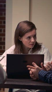Vertical video: Project manager talking with employee in business meeting portrait, slow motion. Colleagues brainstorming in boardroom