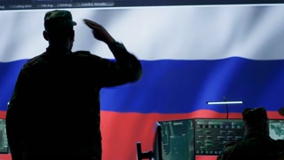 Russian army soldier presenting the official salute in operations room, inflicting propaganda and misinformation to cause fear among the