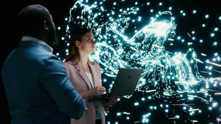 Team of programmers optimizing neural network neurons map with laptop and augmented reality tech. Teamworking colleagues fine tuning AI