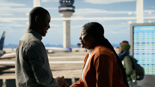 Proud parents thrilled about grown-up child independence as exchange student. Black cheerful mother and father stand in the terminal smiling