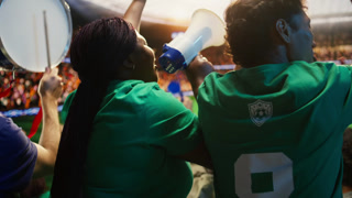 Football supporters chant with in packed sports arena, reacting to goal. African american woman towards soccer pitch, creating loud stadium
