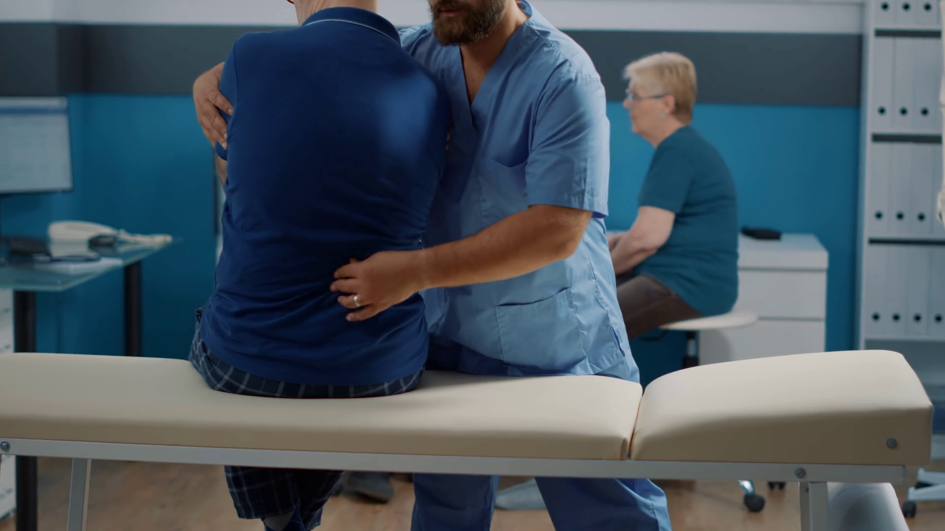 Male doctor cracking back bones to heal man with spinal cord injury