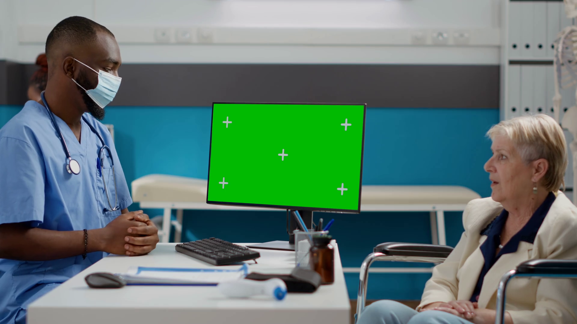 Assistant with face mask and woman in wheelchair using greenscreen