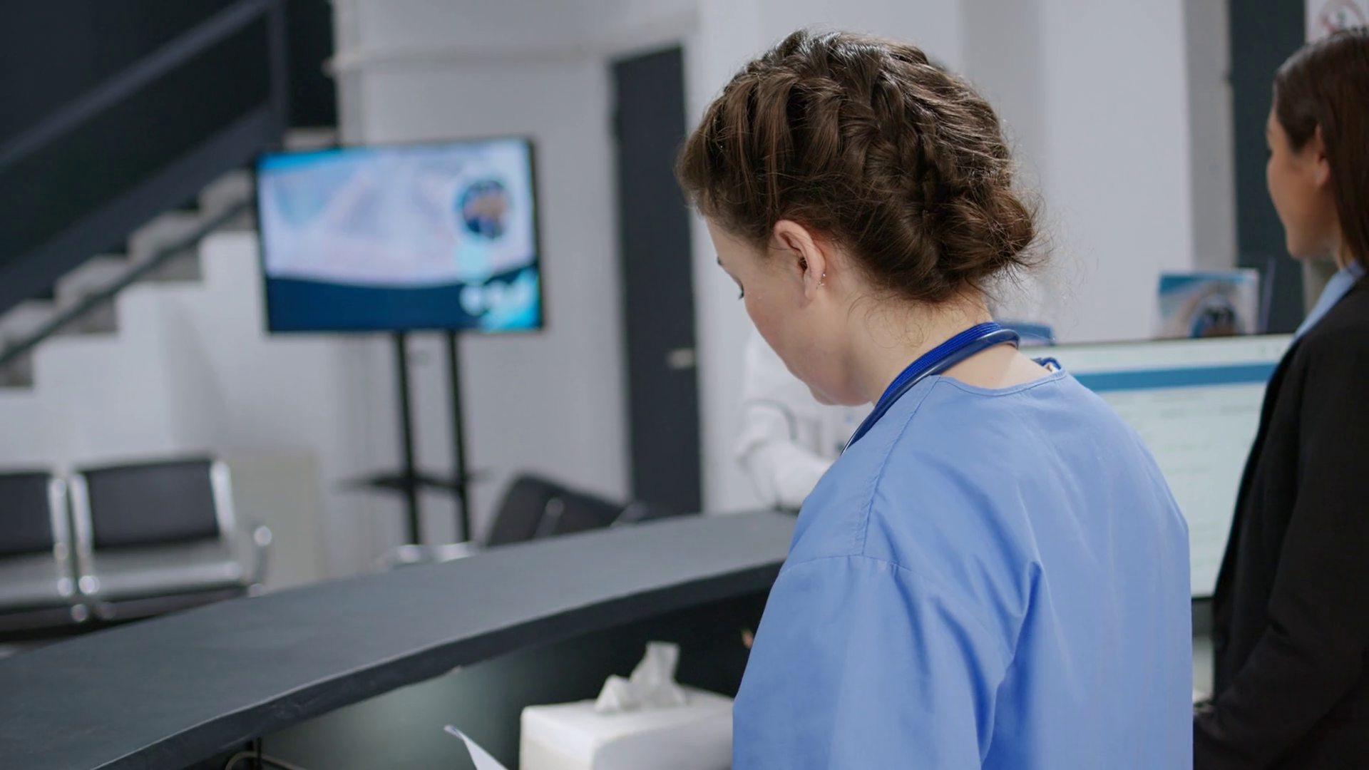 Medical assistant helping senior patient with appointment and reception registration counter in