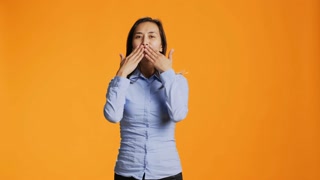 Flirty asian person blowing air kisses in studio, acting sweet with romantic gesture in front of camera. Young woman with casual clothes