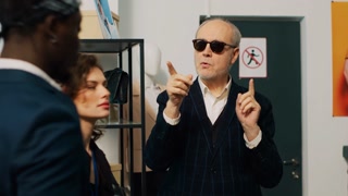 Experienced designer and sponsor of the retail store asks for elegant accessories, talking to boutique employees about a new clothes