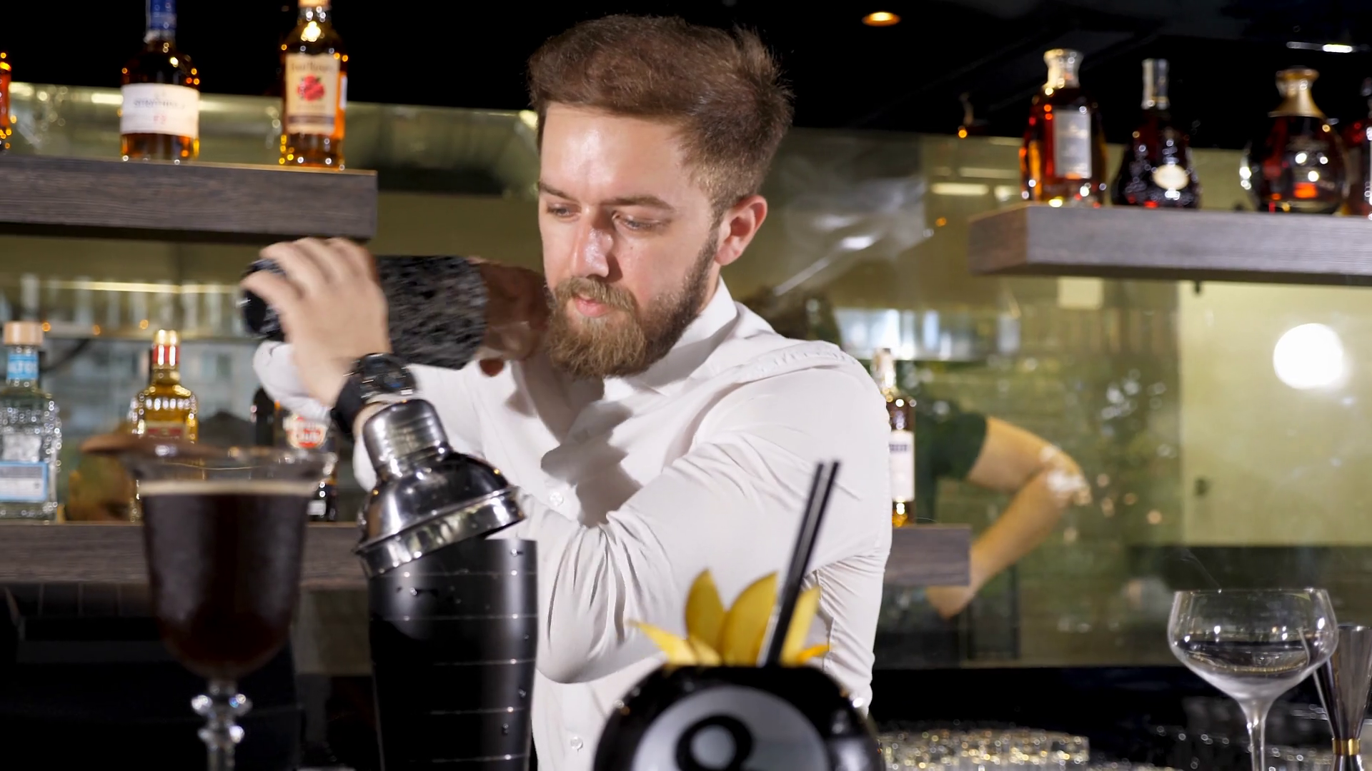 Bartender shaking a cocktail in shaker at his bar table Stock Video