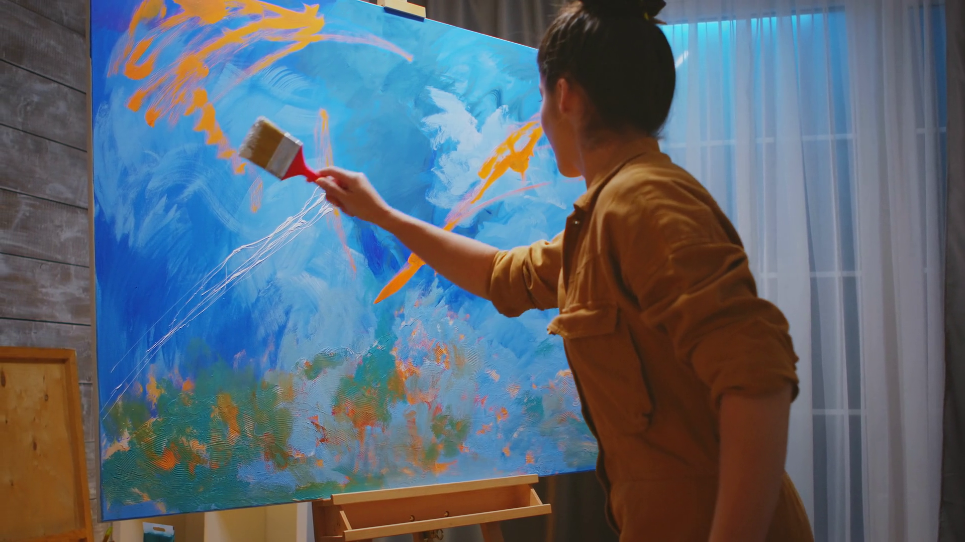 Confident young painter using hand technique on new painting. Stock