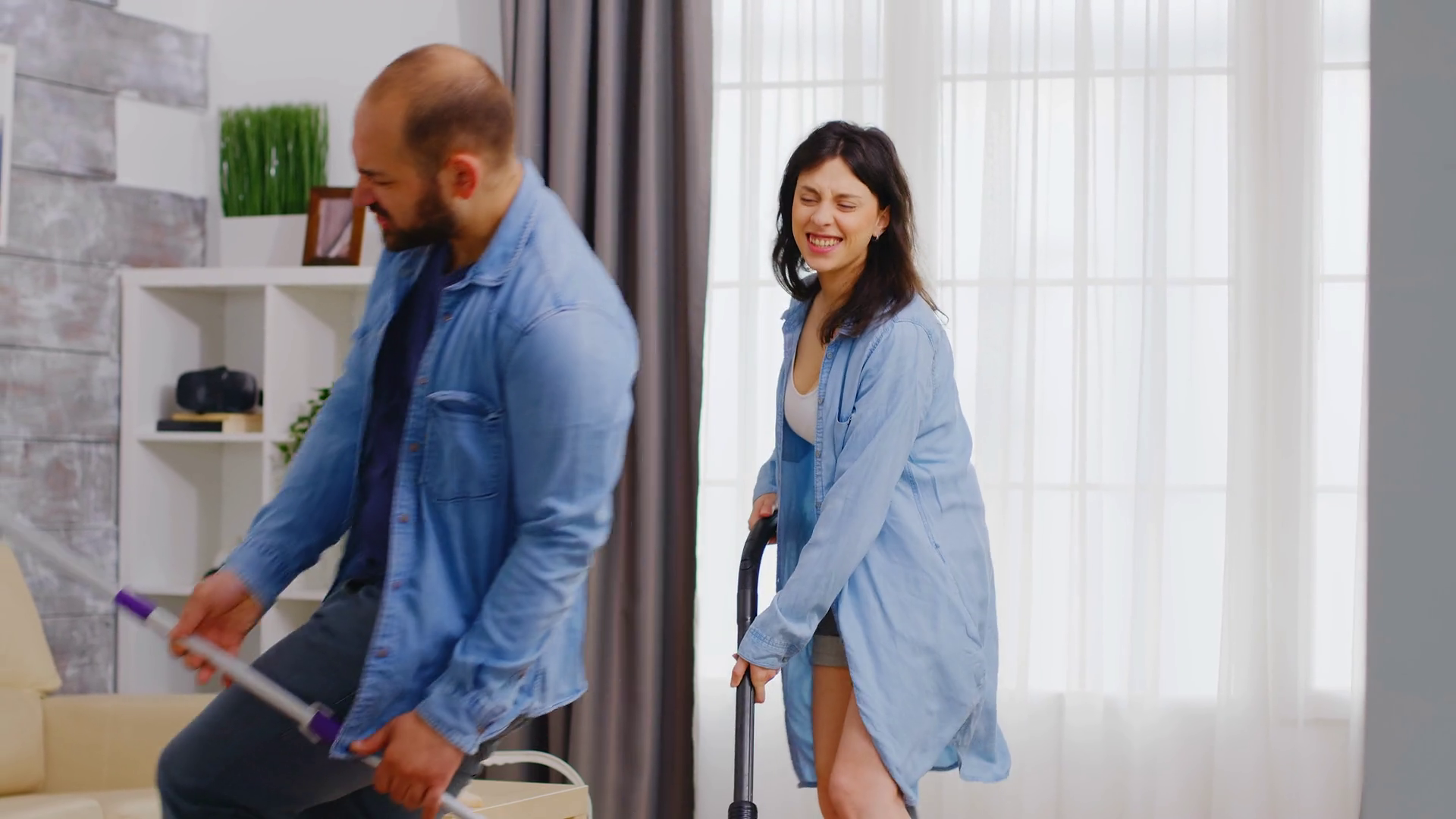 Husband dancing with mop while cleaning the house together with