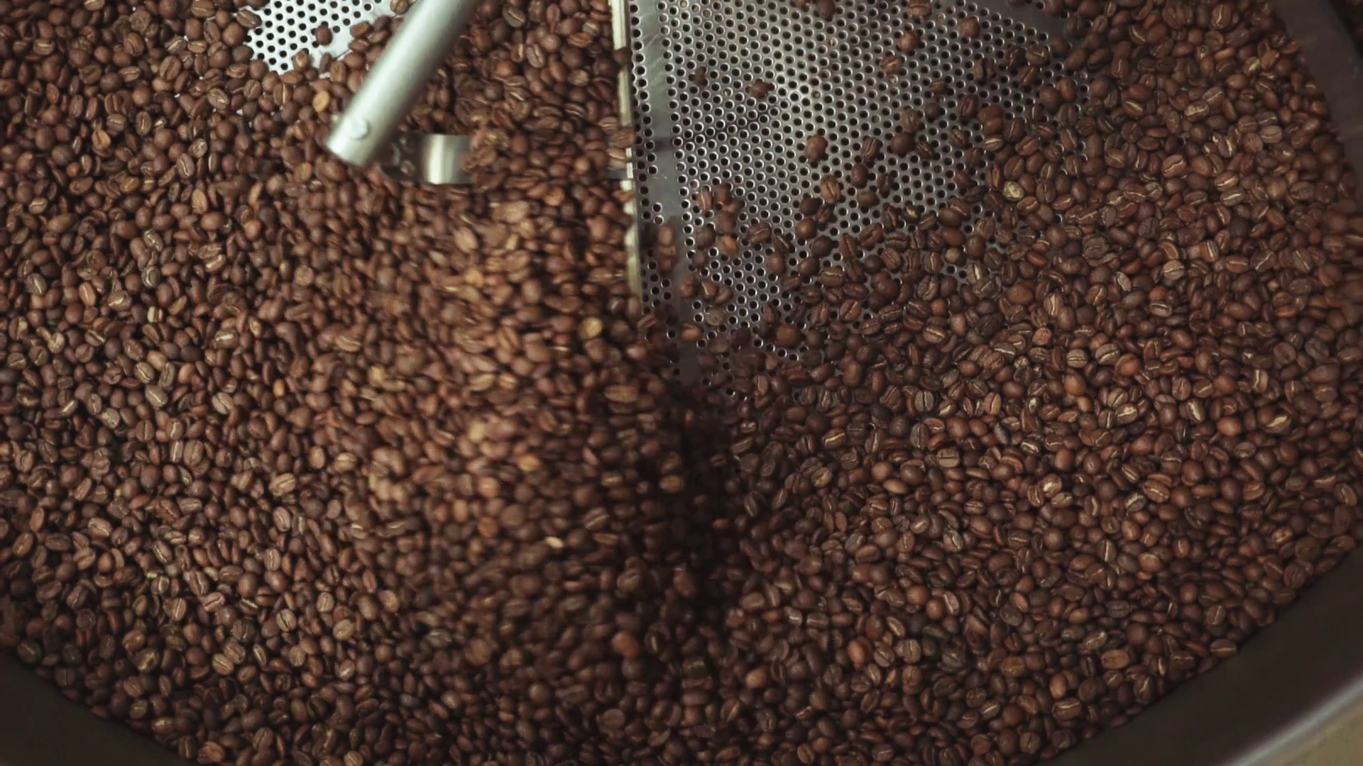 Aerial, high view of mixing roasted coffee beans. Traditional coffee