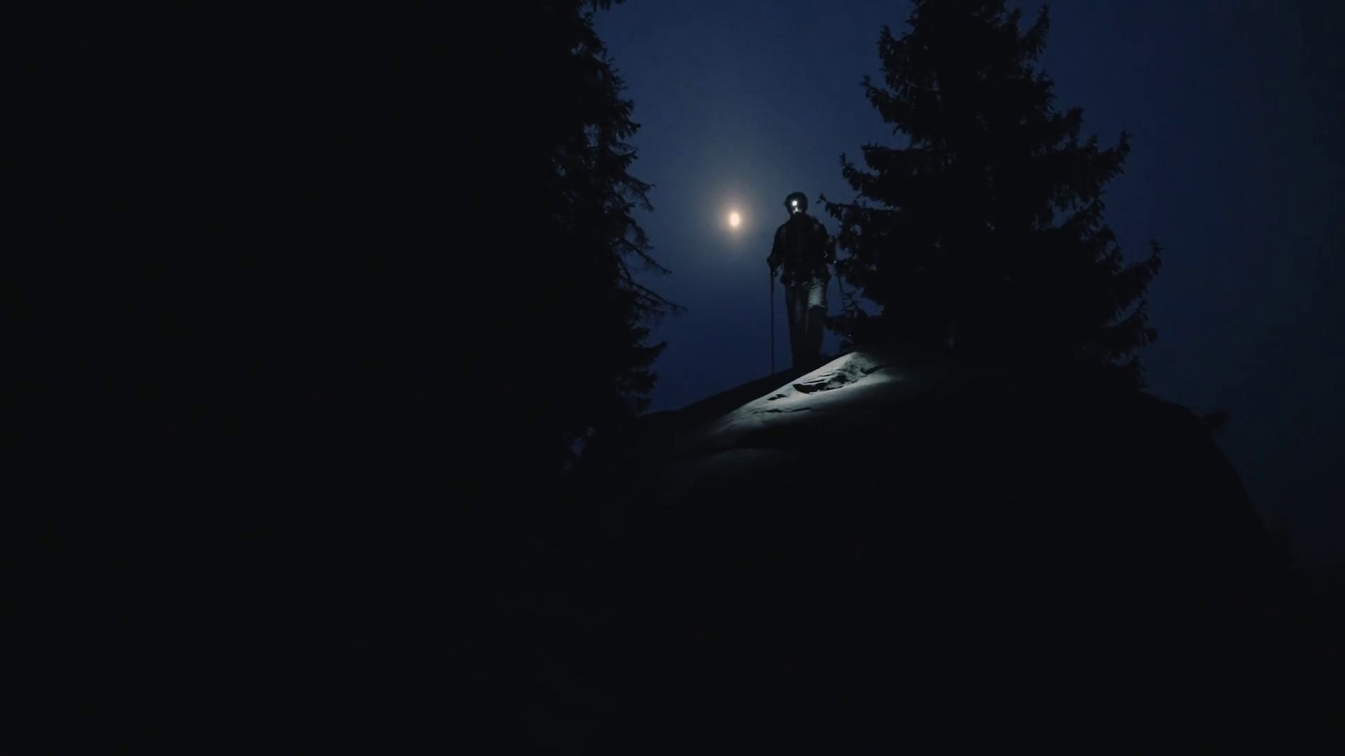 Close up man walk hiking through a dark rocky mountains shining through