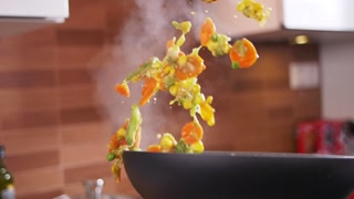 Close-up of person cooking vegetable dish with funny mishap in the kitchen