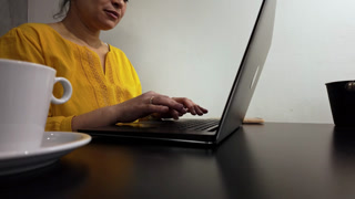 Focused Woman Working on Laptop in Cafe, Enjoying Coffee