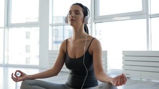Inner Serenity: Close-Up of Young Woman in Yoga Pose, Meditating to Soothing Music