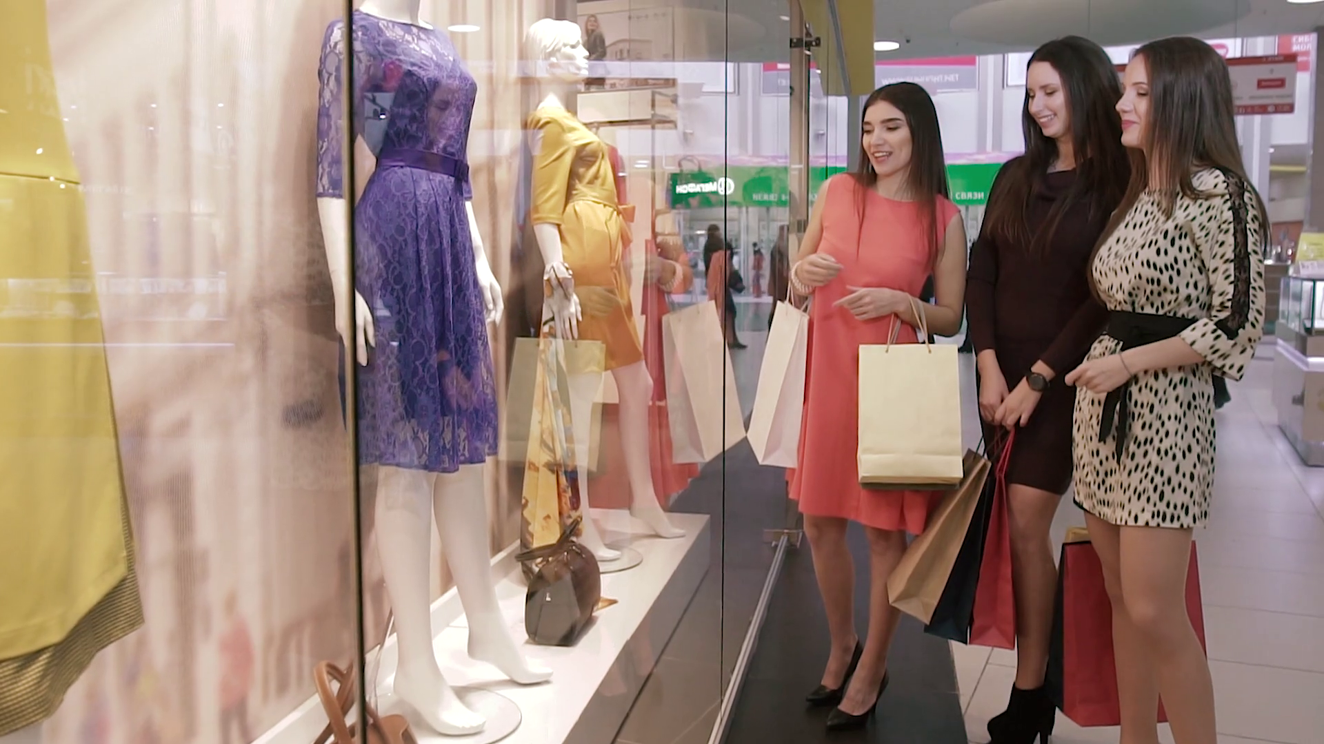 Three nice shopping women in shopping center discussing the clothes in ...