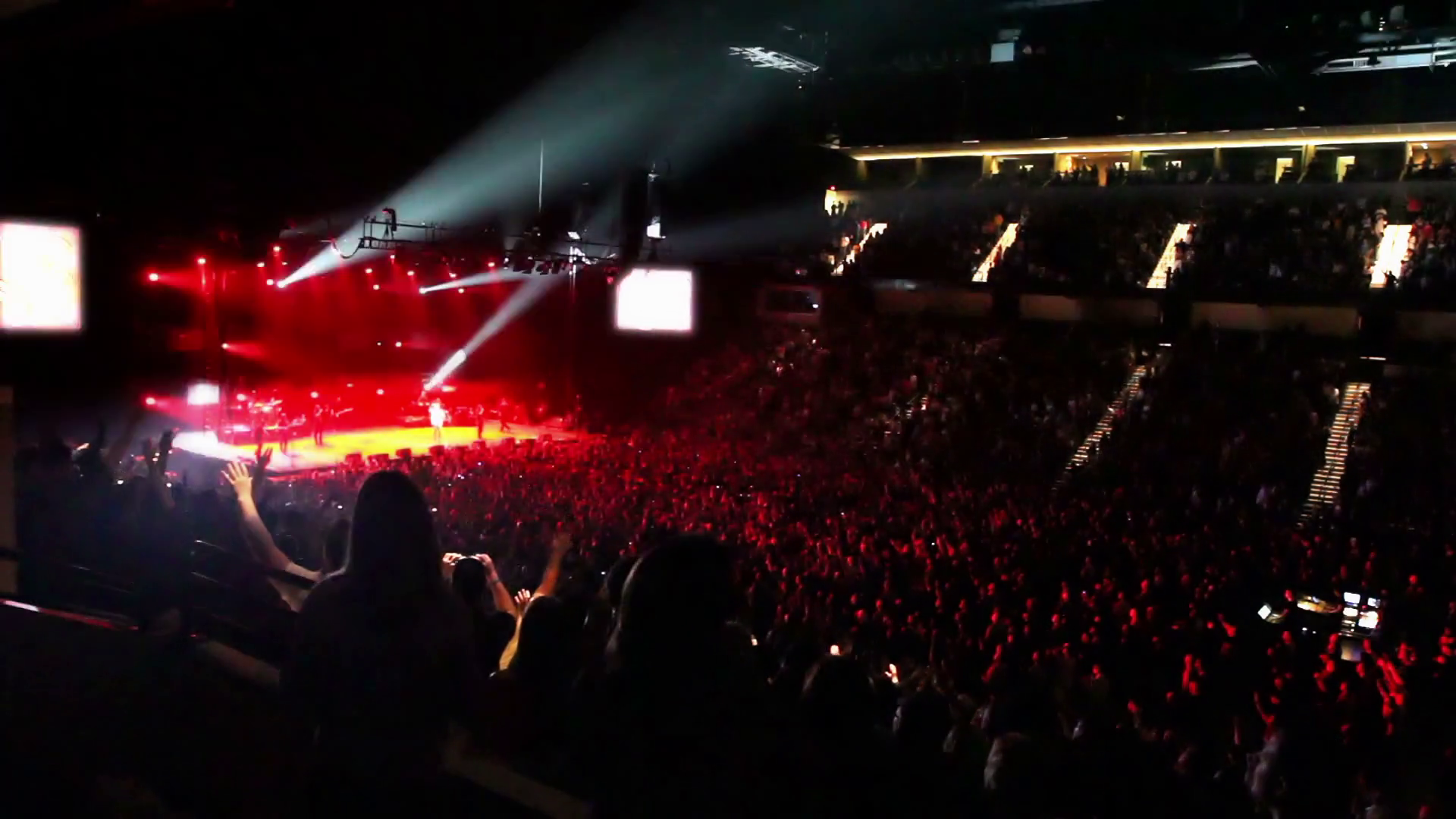 Flashing strobes and spotlights at a rock concert with a huge crowd of