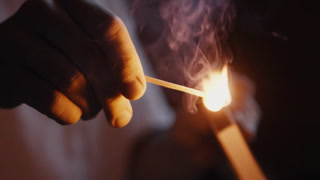 Macro shot of a match being lit through friction with the striking surface