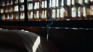 Incense stick smoke rising in sunlight