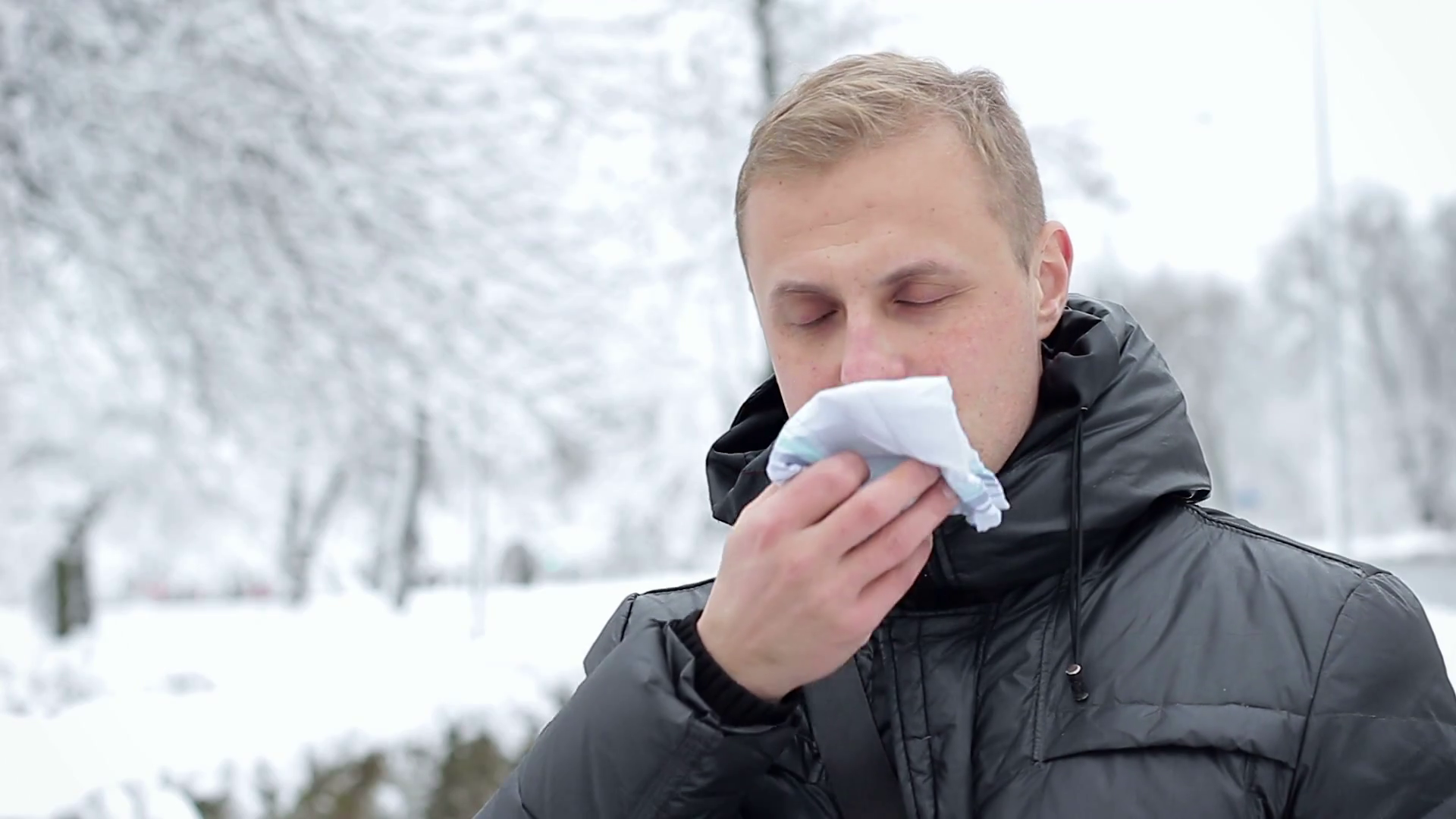A person with cold or flu symptoms on the street using a handkerchief without a headdress Stock