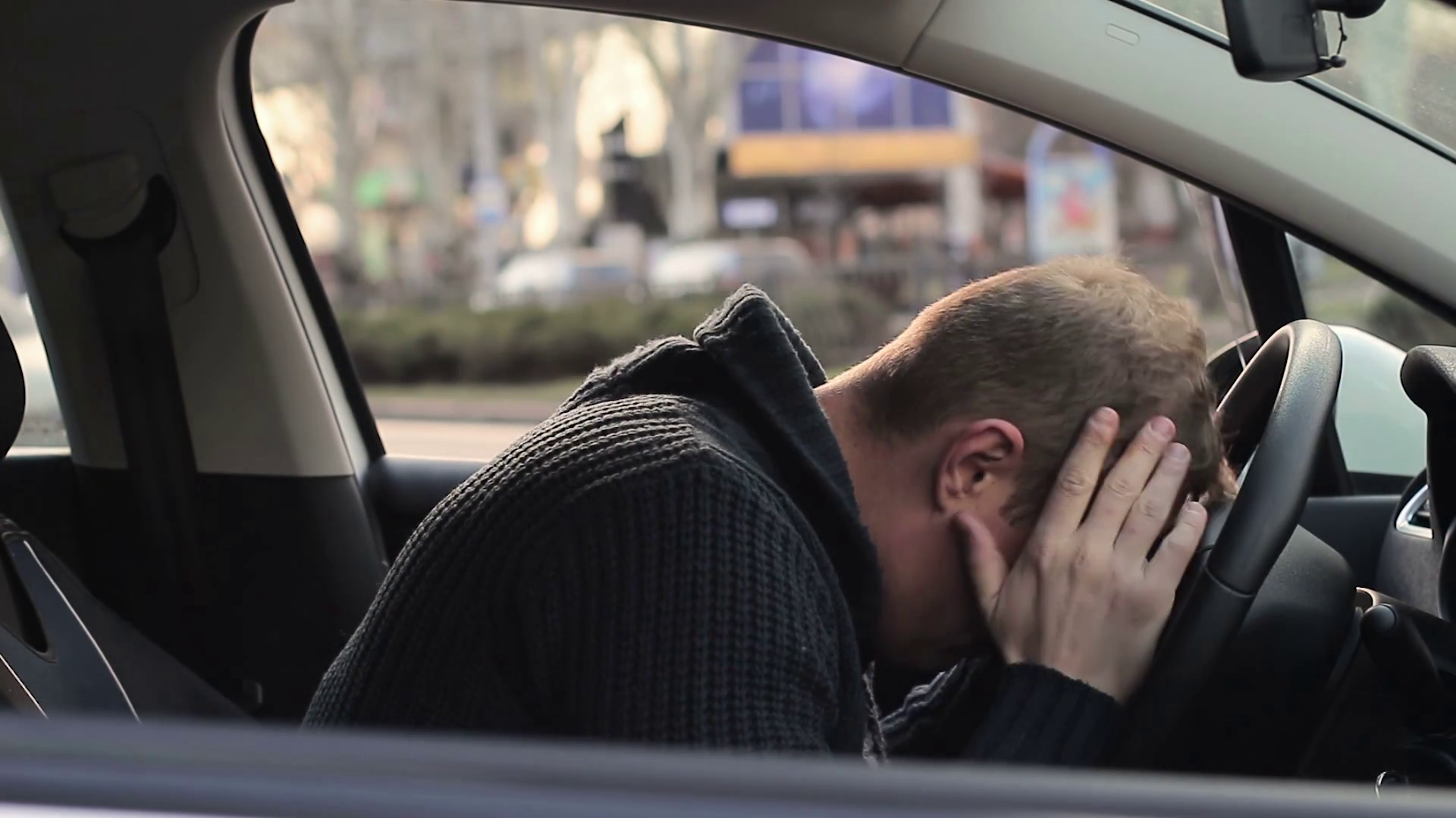 depressed and very upset young man in the car. problems in