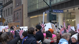 2017 Women's March protesters hold signs and march along East 42nd Street in NYC