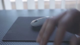 Black man moving his mouse at his desk