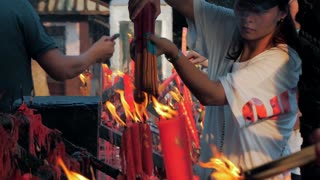 Suzhou, China - October 3, 2019: Burning candles in buddhist temple. People set candles and incense sticks.