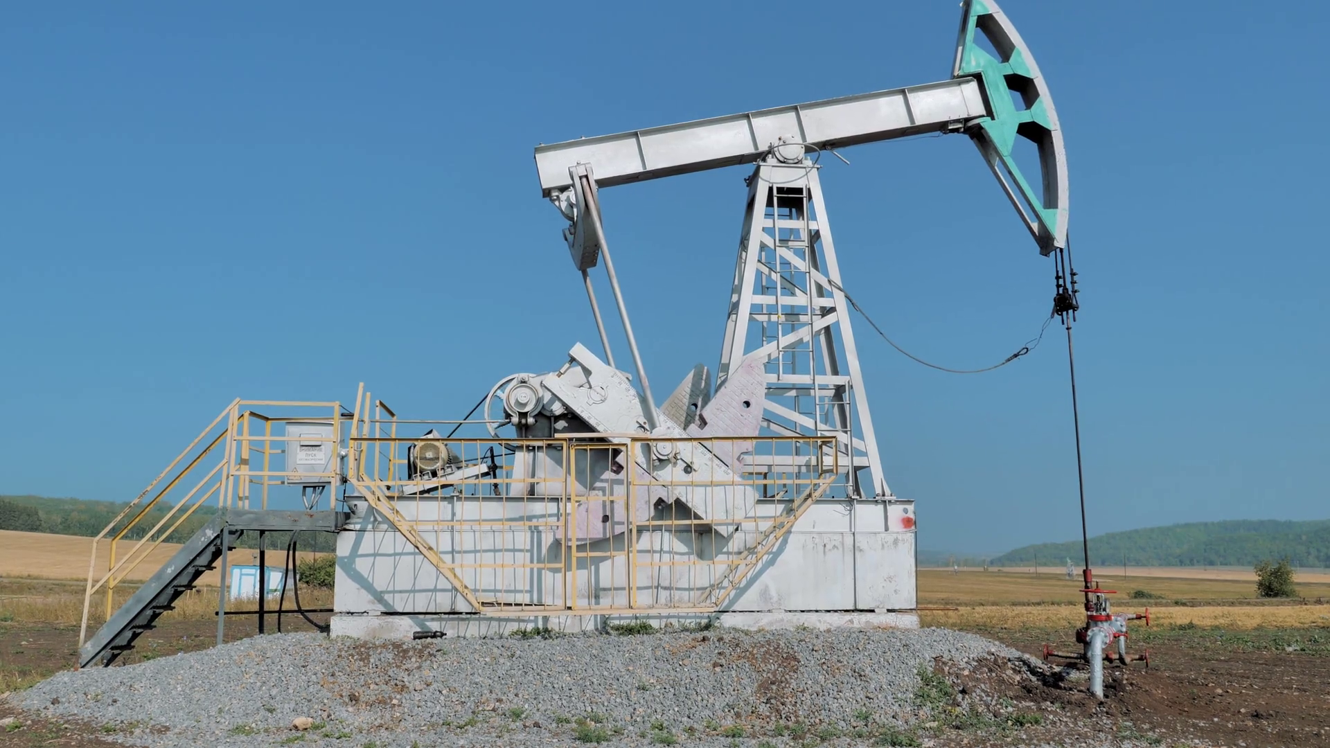 Pumping rig extracting oil from an oil well in vast oil field. Oil ...